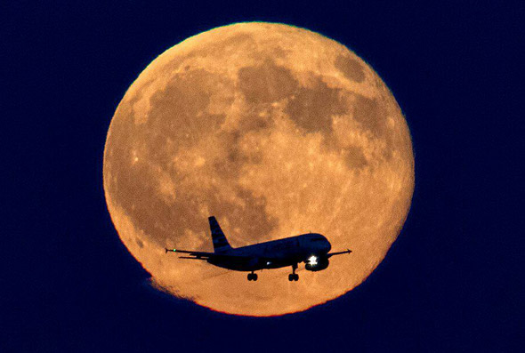 Airplane in front of blue moon