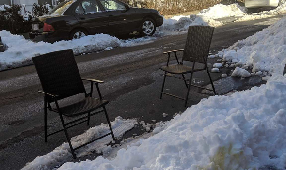 Two chairs used as space savers on Sutherland Road in Brighton