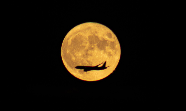 Plane flying across tonight's full moon