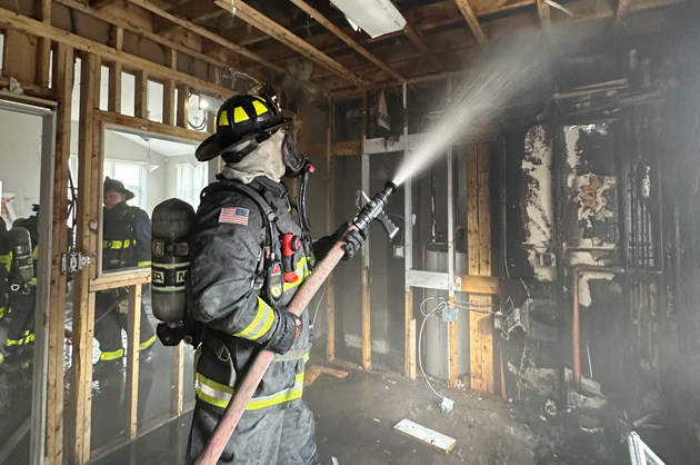 Firefighters washing down burned room