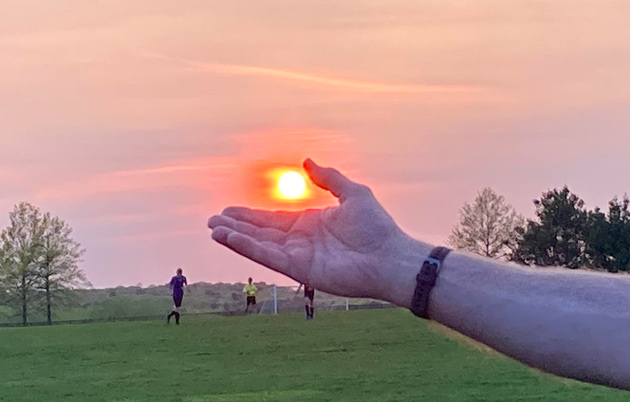 Hazy setting sun captured in hand at Millennium Park