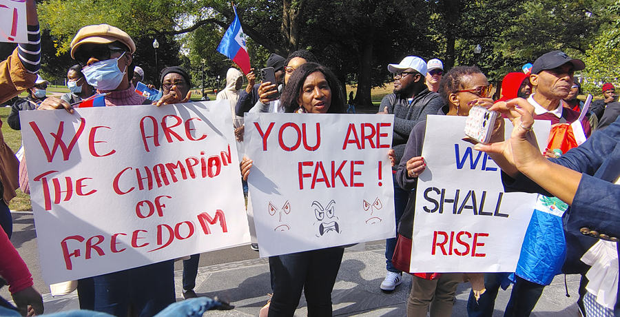 Haitians on the Common with signs supporting the community