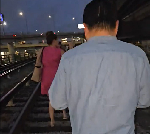 Passengers walking on Orange Line tracks