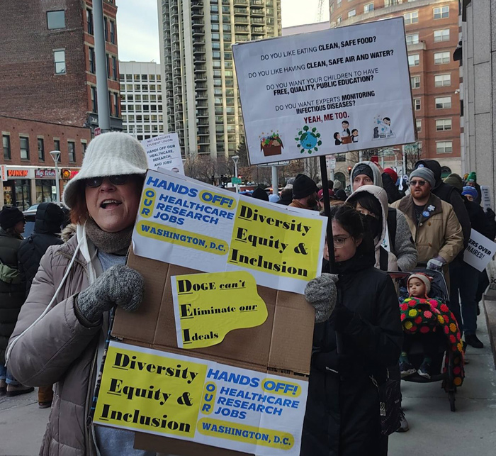 Protesters outside the O'Neill Building with signs supporting government workers, DEI