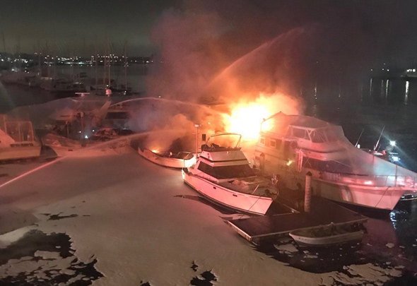 Boat on fire in Charlestown with lots of firefighting foam nearby