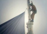 Guy attaching Patriots flag to the top of the Old Hancock in Boston