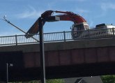 Backhoe rips up a light pole on the Casey Overpass in Forest Hills