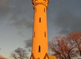 Orange Fort Hill water tower at sunset