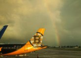 Plain with a Bruins tail in front of a rainbow