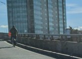 Person riding a Blue Bike onto the turnpike