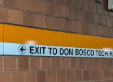 Wayfinding sign pointing Orange Line riders to Don Bosco Technical High School