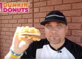 Guy holding a Dunkin' Donuts Belgian Waffle Breakfast Sandwich