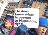 Man holding sign that asks: He does know what happened to Napoleon, right?