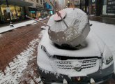 Satellite and smashed car on Washington Street downtown in the snow