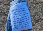 Blankets in a bag tied to a pole at the start of a path that thank the lender for helping save their dog