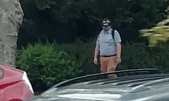 Man with VR headset walks down Beacon Street in Brookline