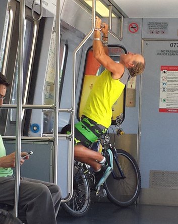 Guy on bike doing pull ups on the Blue Line