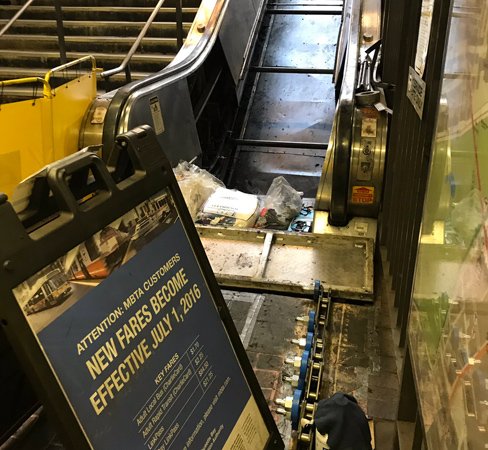 Sign about MBTA fare increases used to block people from a non-working MBTA escalator