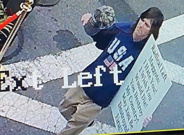 Guy with sign wishing death on people eating dinner outdoors in Marblehead