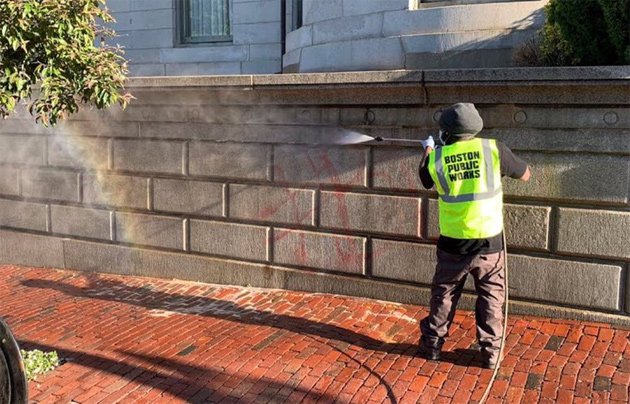 Public Works employee removing graffiti