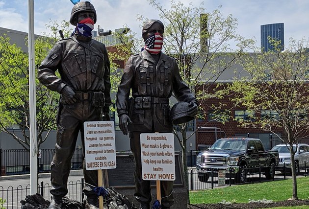 Statues of soldiers with masks in the South End urging people to stay home