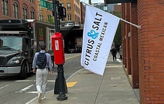 Restaurant flag taking up much of the sidewalk at A and Melcher