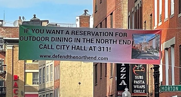 Banner across Salem Street urging people to call 311 to complaint about outdoor patios