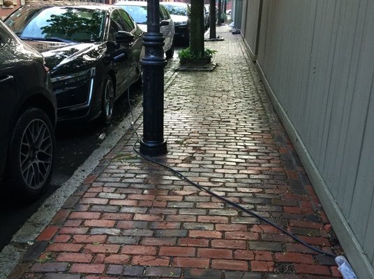 Electric-car charging cord on sidewalk