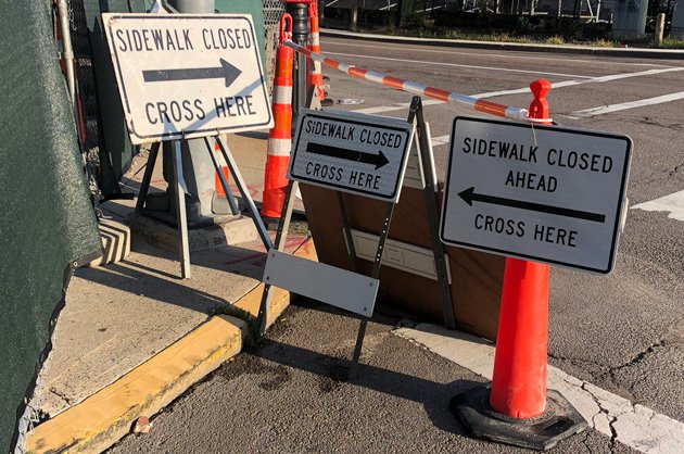 Signs pointing pedestrians in conflicting ways in the South End, near the Ink Block