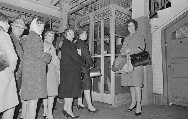 People waiting to make phone calls in a downtown Boston subway stop