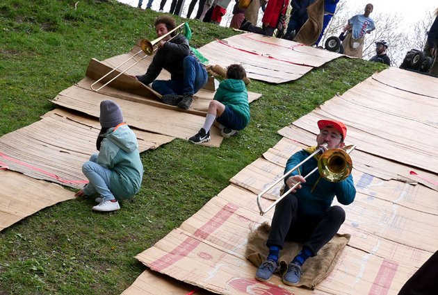 Tromboinists do slides on a slide at Wake Up the Earth