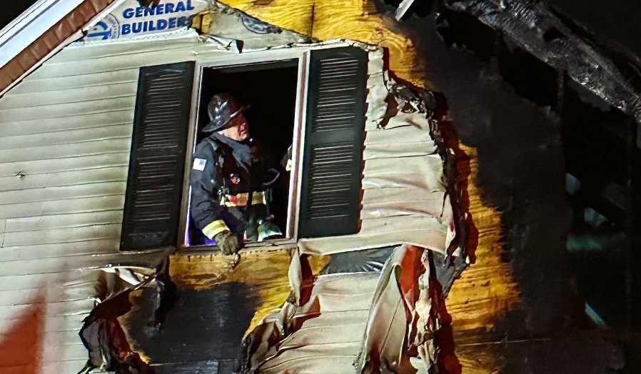 Firefighter surveys damage from window