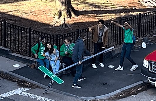 Downed sign with people quite happy about it at Bolton and D streets in South Boston