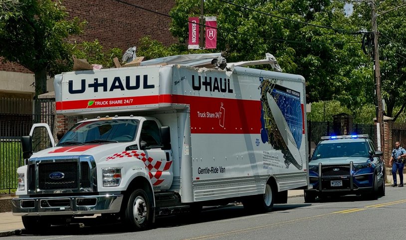 U-Haul with its roof peeled back by the North Harvard Street Bridge