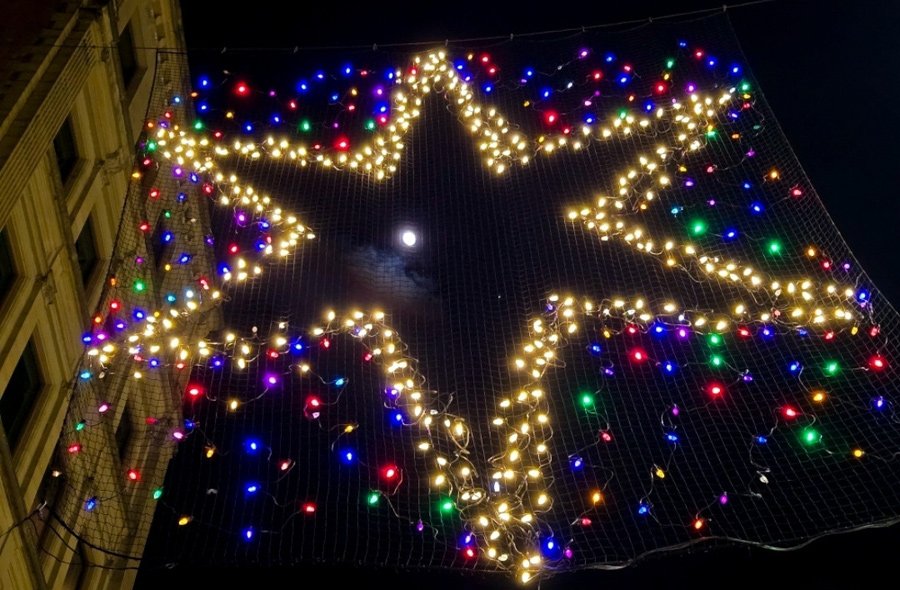 Moon and Venus seen through an illuminated star above Downtown Crossing