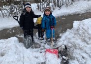 Two kids shovel out a hydrant in Roslindale
