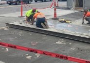 Workers reinstalling brass trash at Haymarket