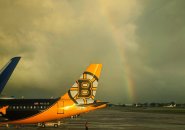 Plain with a Bruins tail in front of a rainbow