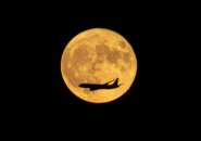 Plane flying across tonight's full moon