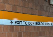 Wayfinding sign pointing Orange Line riders to Don Bosco Technical High School