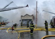 Firefighters pour water on Russo's fire