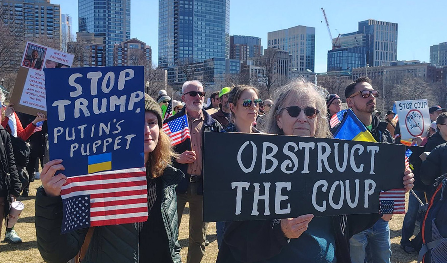 Women holding signs on the Common: Trump is Putin's puppet and Stop the coup