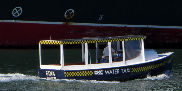 Water taxi goes by the Queen Mary 2