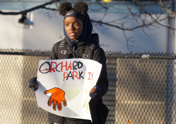 Girl with sign outside Orchard Gardens School