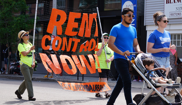 People with a sign calling for rent control now