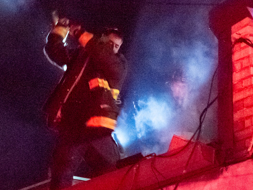 Firefighter cutting hole in roof