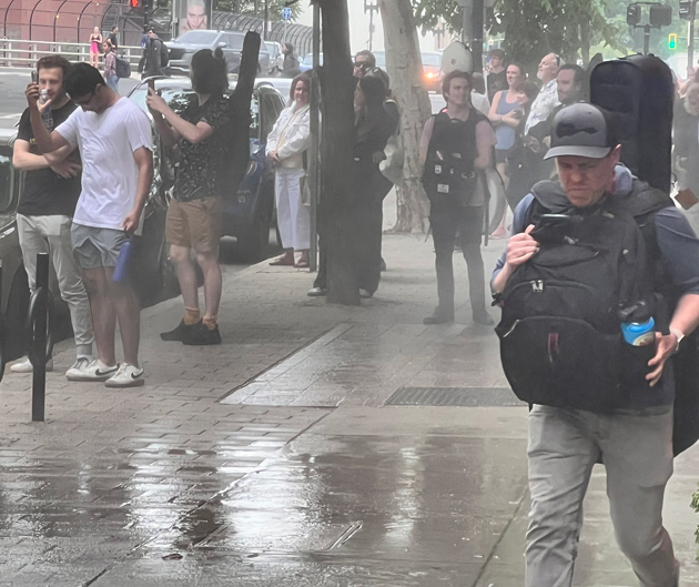 Wet people, sidewalk across from the Hynes