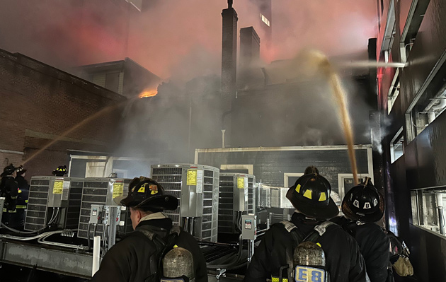 Firefighters pour water on building